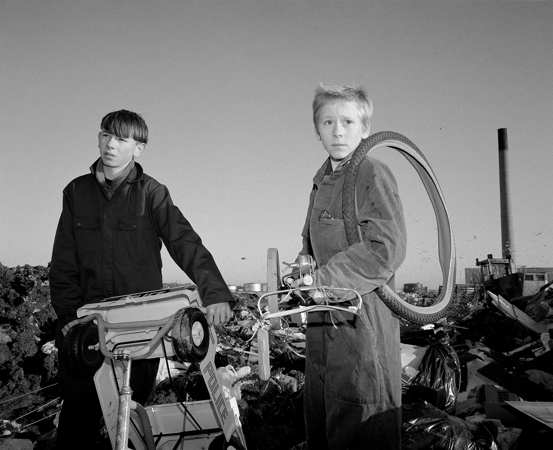 artist photograph showing two young men in a refuse centre with items they have found.