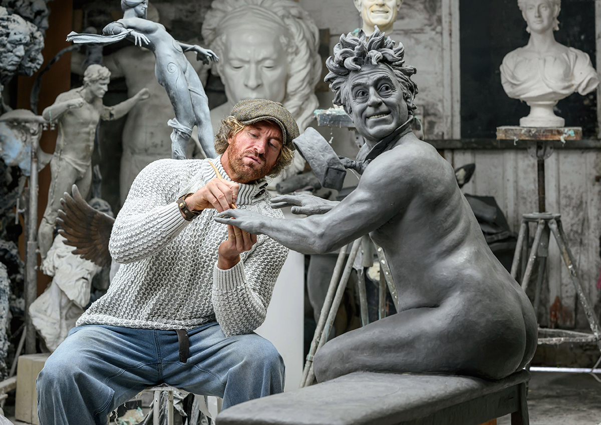 Sculptor working with piece.