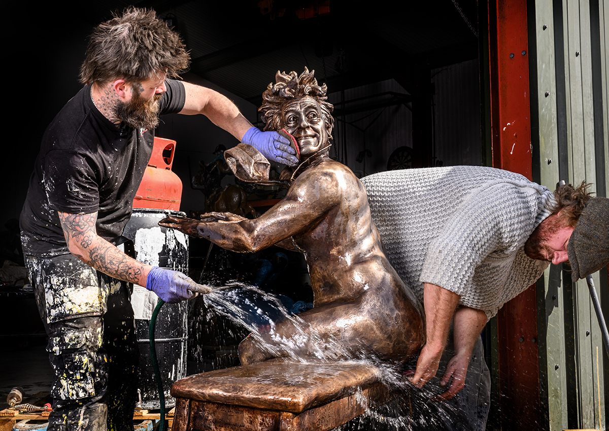 Sculptors applying the finishing touches to a statue.